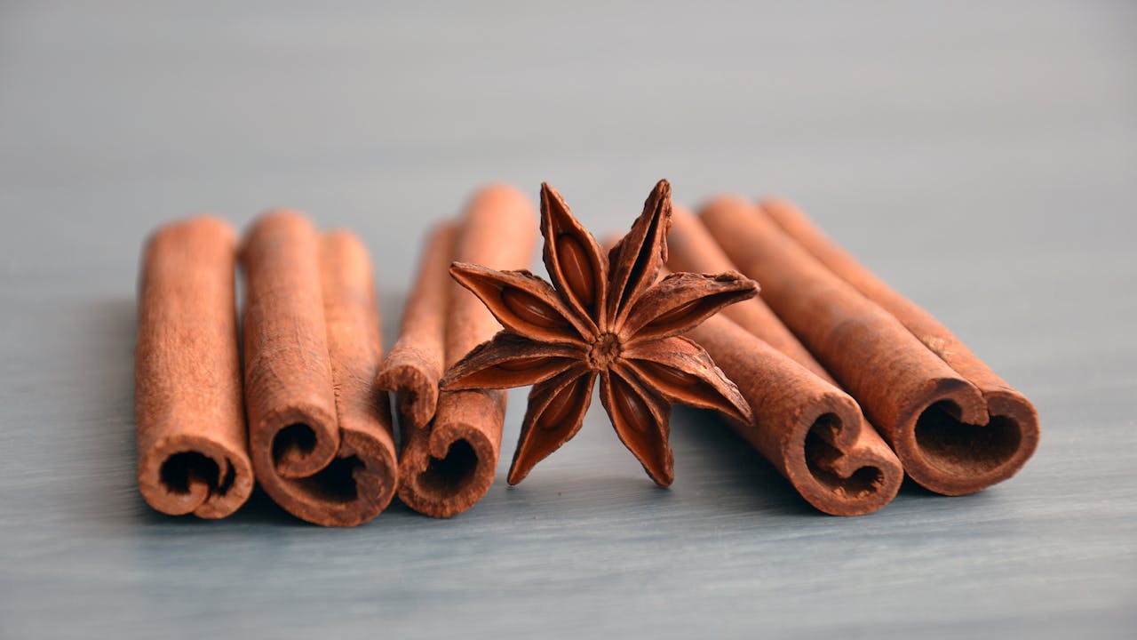 Cinnamon sticks and star anise on a warm wooden surface, representing the botanical ingredients in berberine formulas