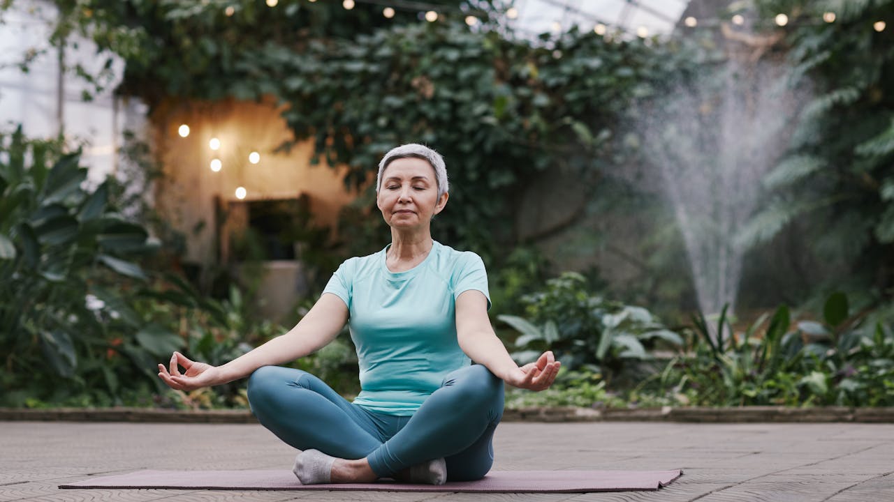 Woman practicing wellness in a peaceful garden setting, representing the active longevity lifestyle