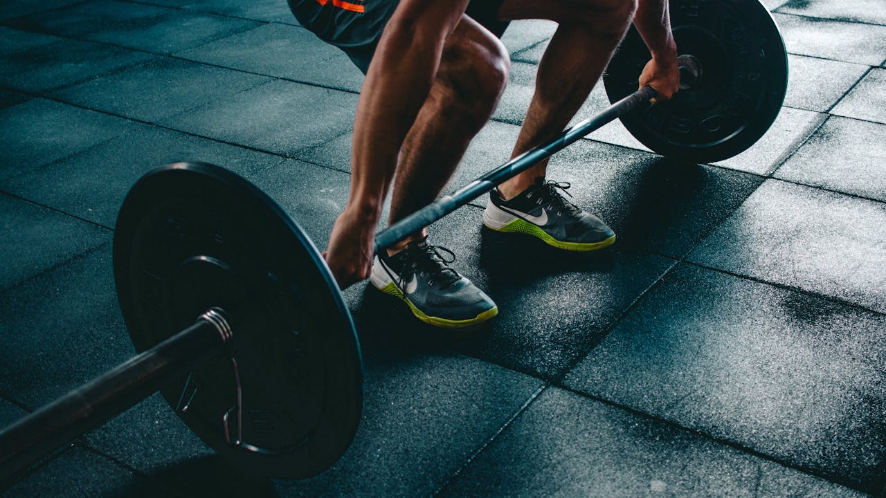 Strength training at the gym, barbell deadlift, fitness performance