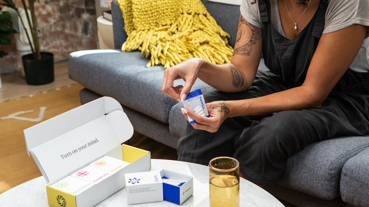 Woman at home taking health supplements as part of her morning wellness routine