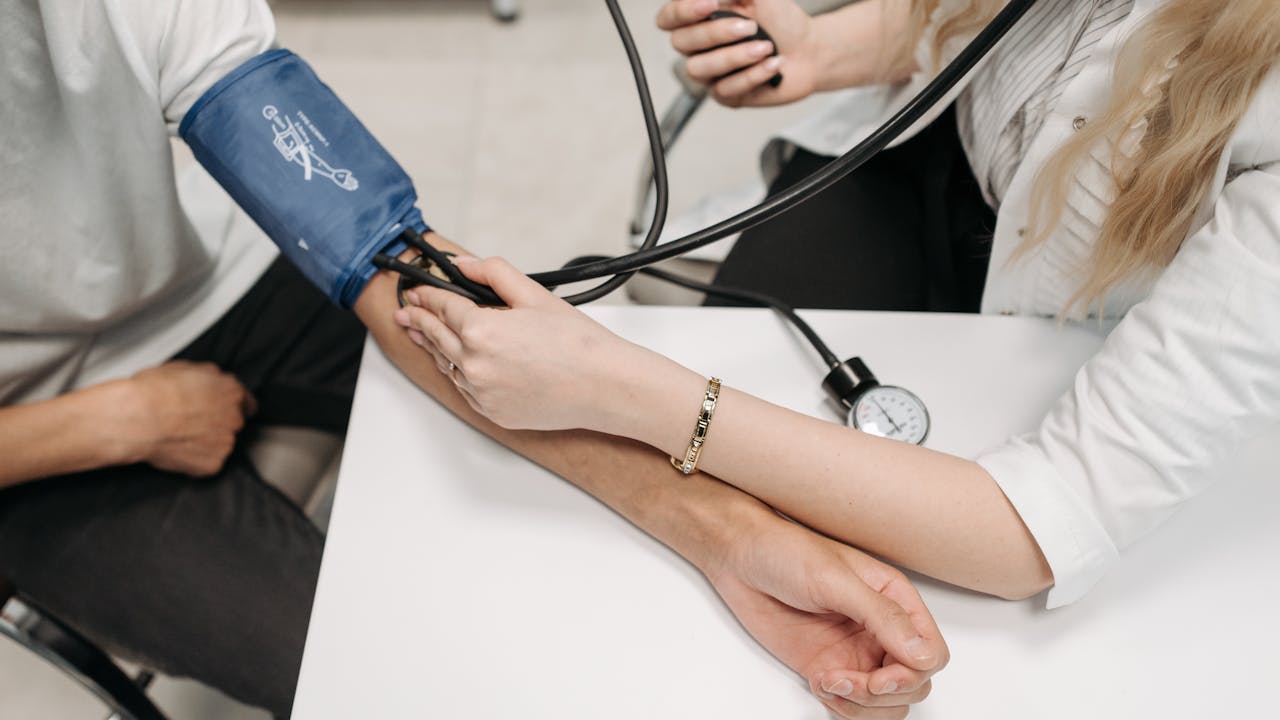 Person checking blood glucose levels with a small monitor, clean white background, health monitoring concept