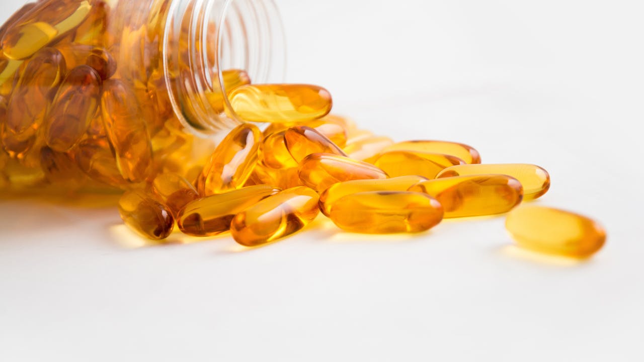 Supplement capsules spilled from a bottle, representing glucose management supplements