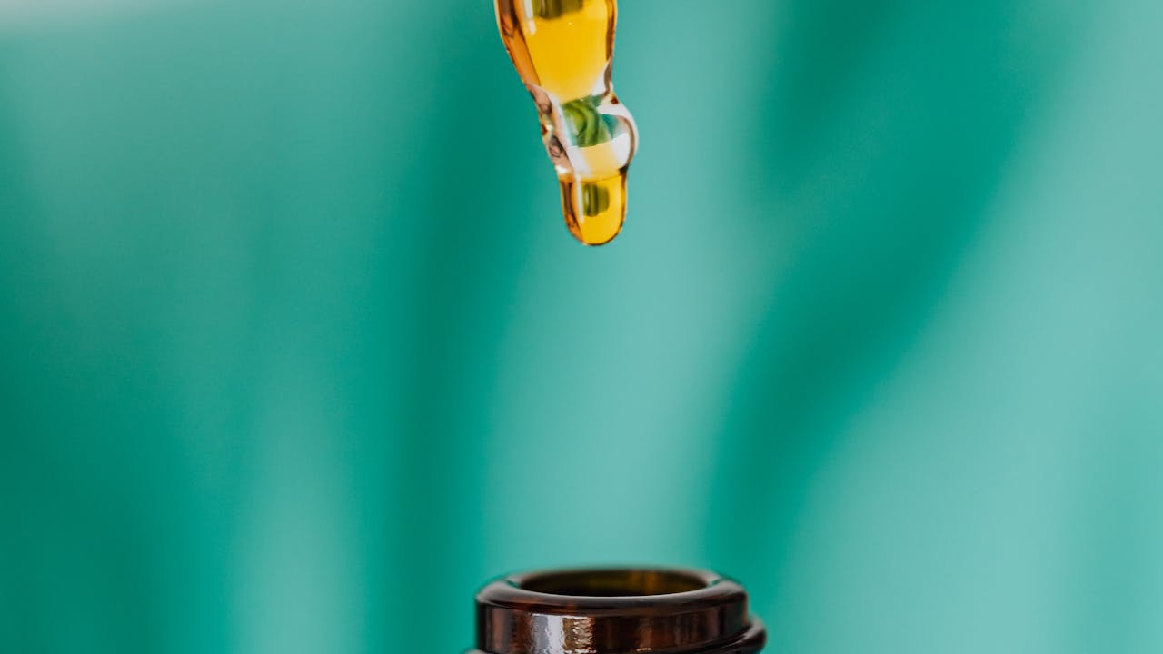 Brown glass dropper bottle with pipette measuring liquid for oral supplementation