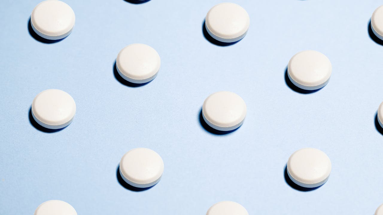 Supplement capsules and powder on marble surface