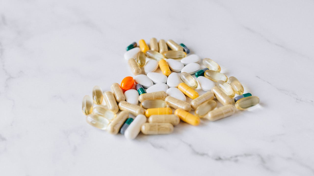 Scientific close-up of clear capsules and molecules visualization, warm golden light, premium health aesthetic