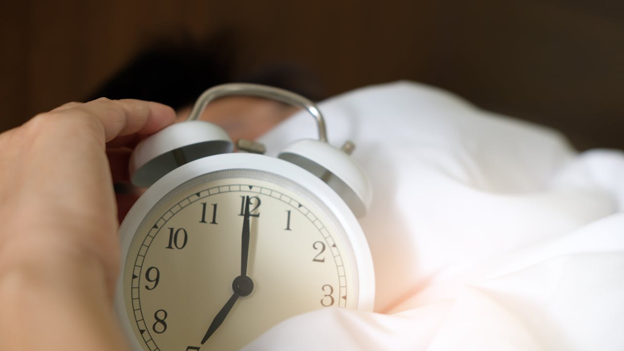 Person waking up refreshed in morning light after quality sleep