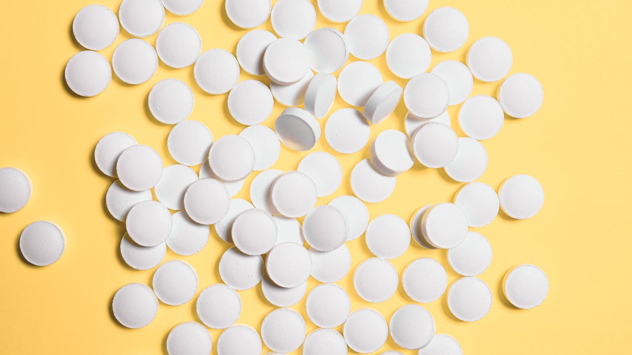 Supplement capsules and tablets alongside a dropper bottle