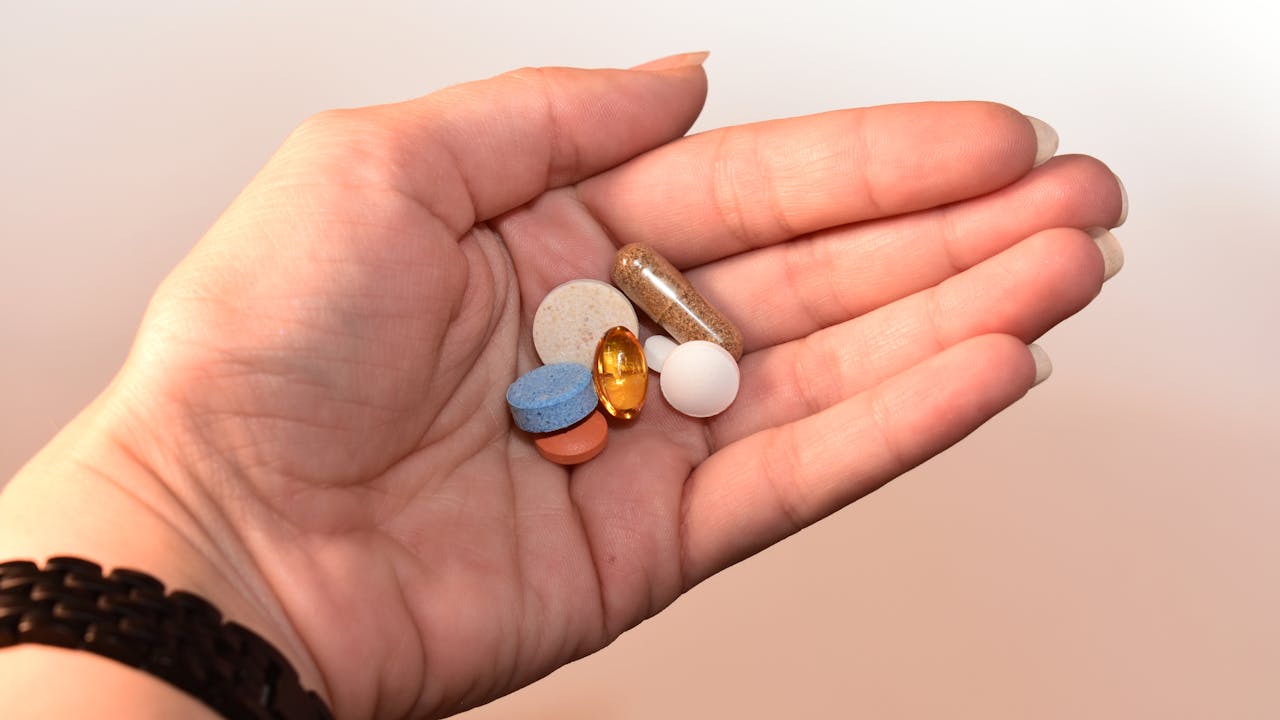 Close-up of supplement capsules in a person's hand, natural morning light